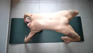 Wife stretches her naked body before training in the gym